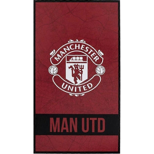 Manchester United, χαλί κόκκινο με λευκό έμβλημα και επιγραφή "MAN UTD" σε μαύρη λωρίδα